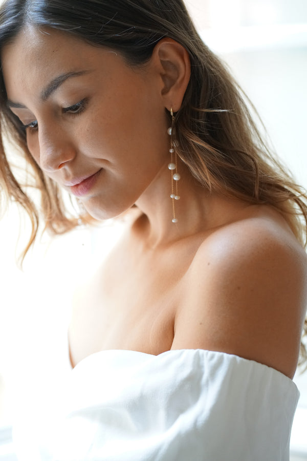 Mariée portant des boucles d'oreilles pendantes à perles naturelles