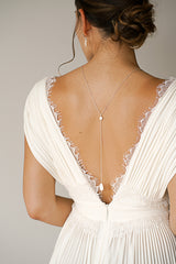 Mariée portant un collier de dos avec pièce en nacre blanc élégant