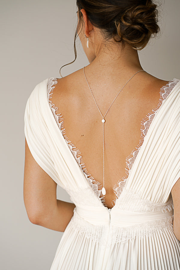 Mariée portant un collier de dos avec pièce en nacre blanc élégant