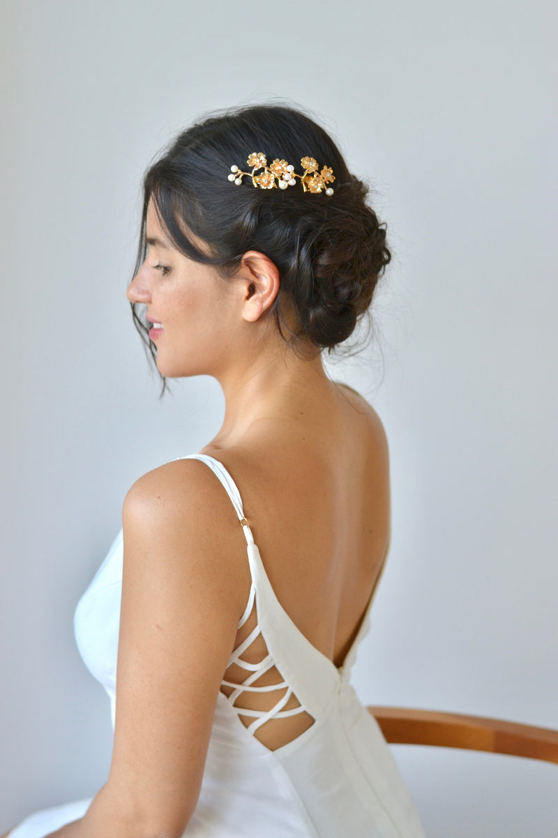 mariée portant un peigne de chignon pour mariage floral en or avec des perles