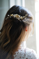 Mariée portant un peigne de mariée bohème à fleurs dorées et perles naturelles