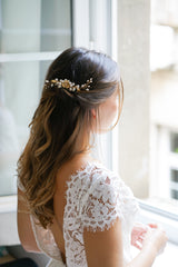 Mariée romantique portant un peigne de mariée bohème à fleurs dorées et perles