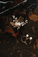peigne mariage et boucles d'oreilles assorties posés sur une table en marbre noir