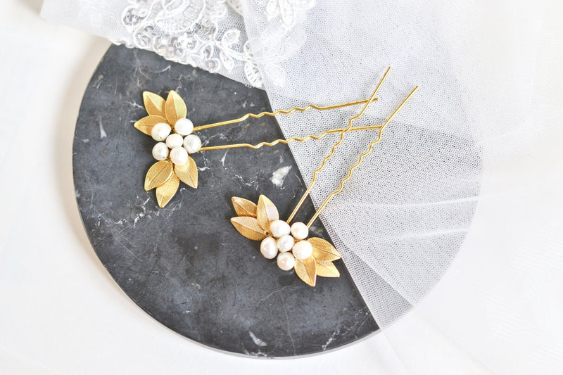 pic de cheveux mariage en forme de fleurs formé avec des feuilles en or et un coeur en perles 