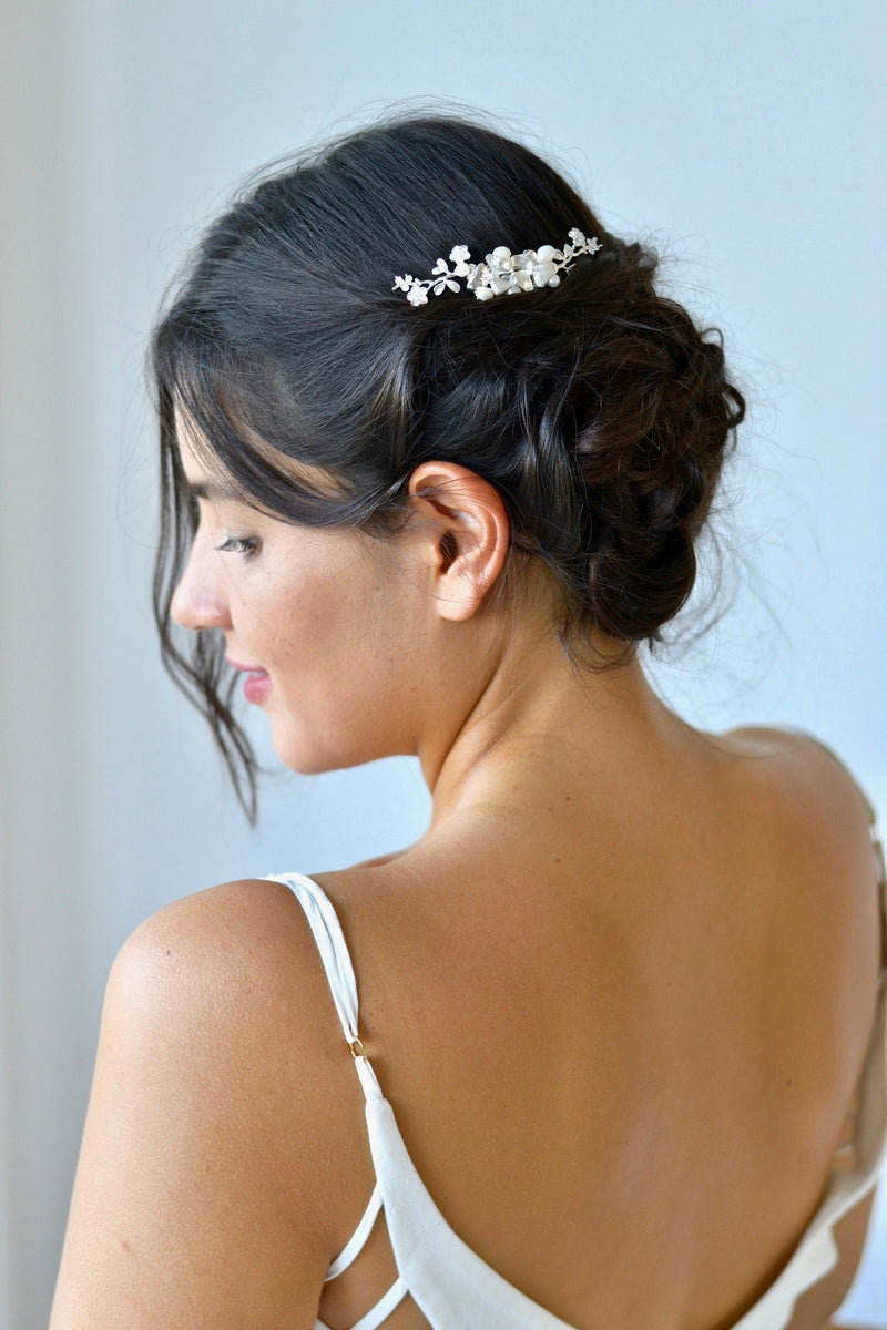 coiffure en chignon avec un peigne de mariage en argent avec des fleurs et des perles