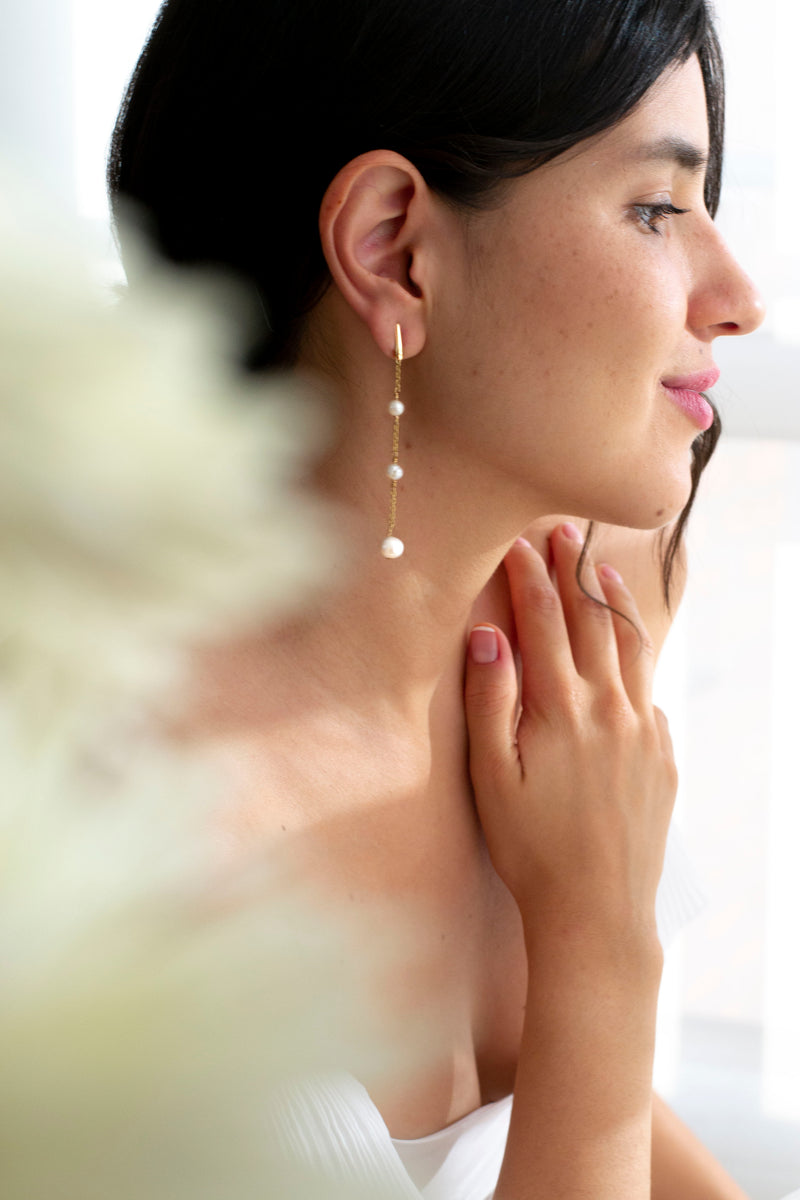 mariée portant des boucles d'oreilles pendantes avec 3 perles naturelles
