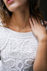 Mariée portant collier minimaliste chaine en or avec une pierre bleue claire