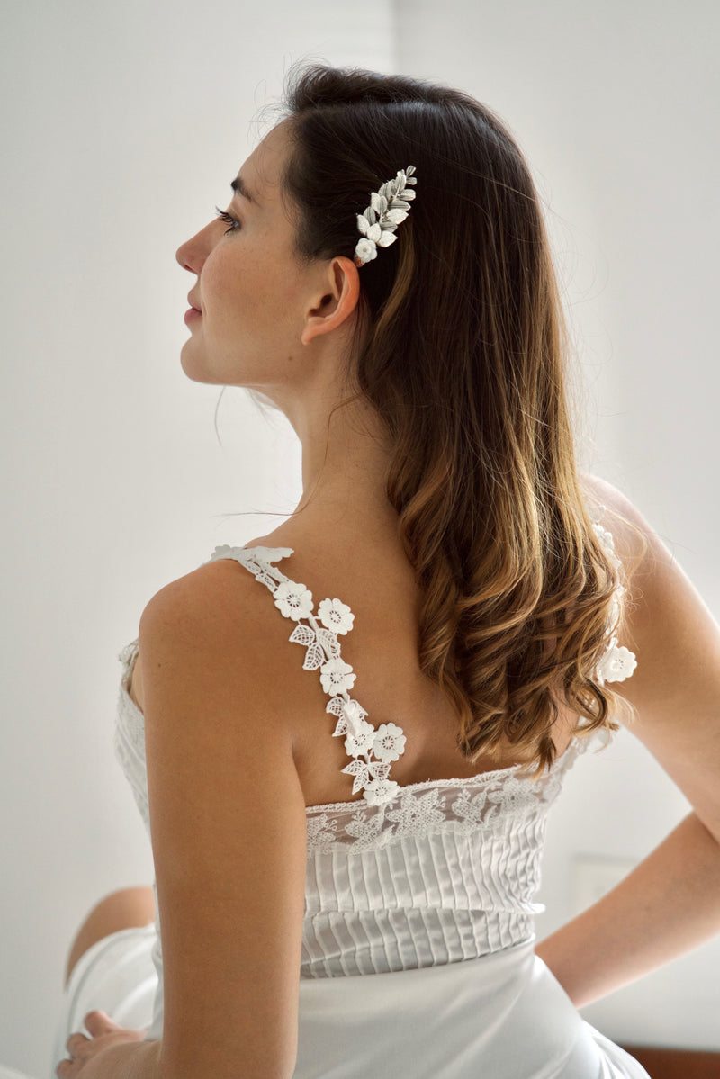 Mariée avec une robe à fleur portant un peigne de mariage argent floral et vintage