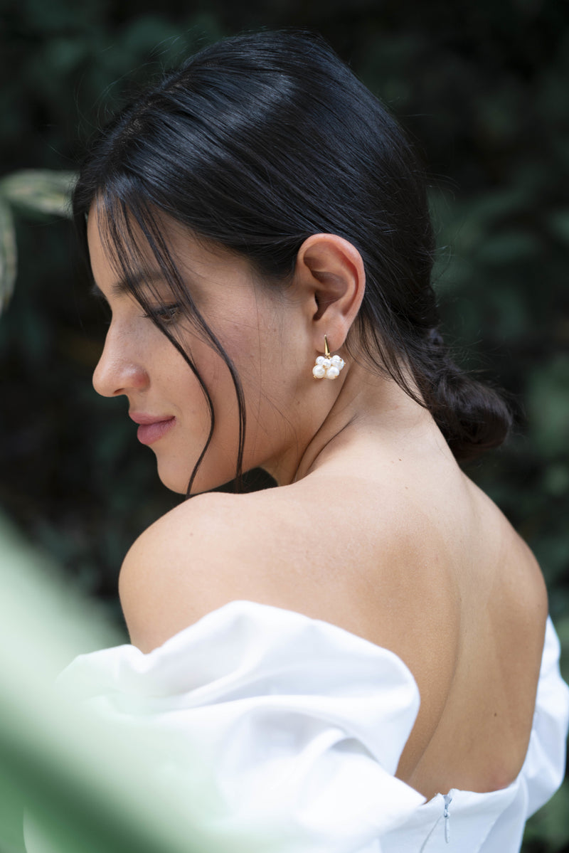 Mariée au style minimaliste et élégant avec boucles d'oreilles en bouquet de perles