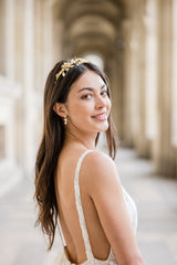 boucles d'oreilles bohème avec un zircon, un feuille en or et une perle naturelle porté par une amriée en cheveux détachés portant un serre tête en or avec des fleurs