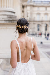Mariée portant un collier de dos de mariage doré et vigne à cheveux florale romantique masjestueuse