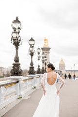 mariée à Paris avec un collier de dos en perles et une robe dos nu sur le pont à Paris
