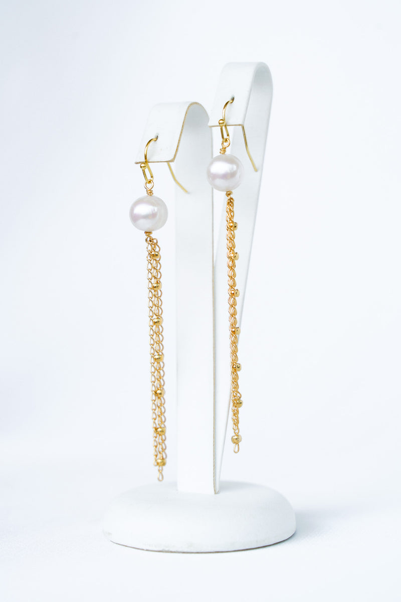 Boucles d'oreilles pendantes élégantes et minimalistes avec une perle naturelle et des chaines dorées