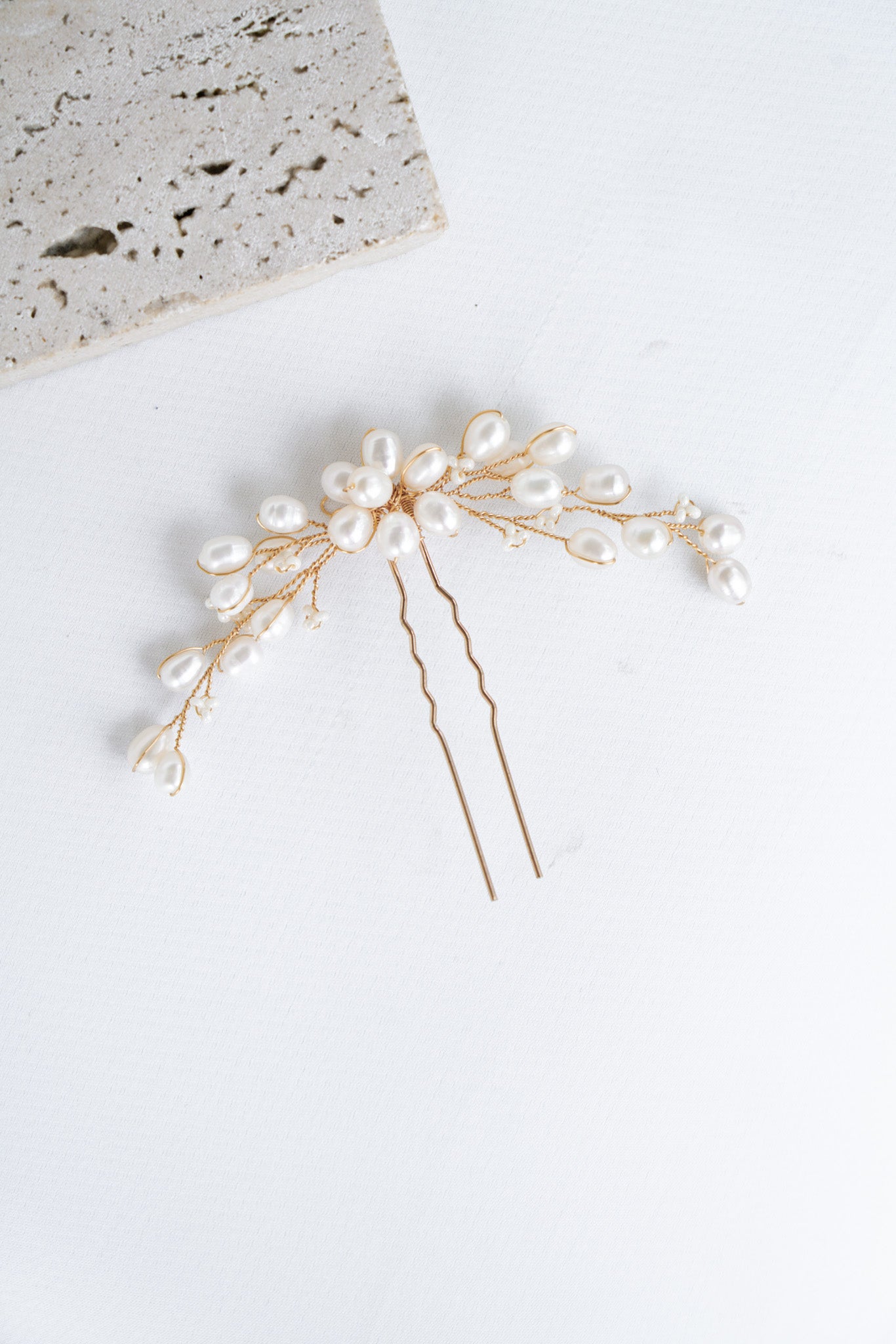 pic de cheveux pour mariage en perles naturelles au style floral sur un fond blanc