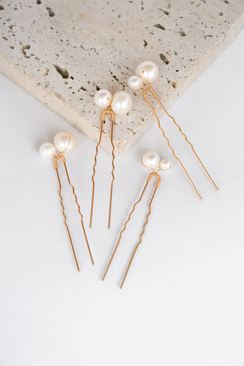 Quatre pics à cheveux dorés avec deux perles naturelles blanches de deux tailles différentes