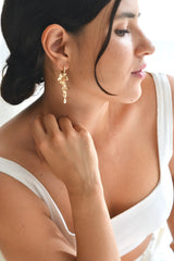 mariée portant une paire de boucles d'oreilles en fleur avec des cristaux