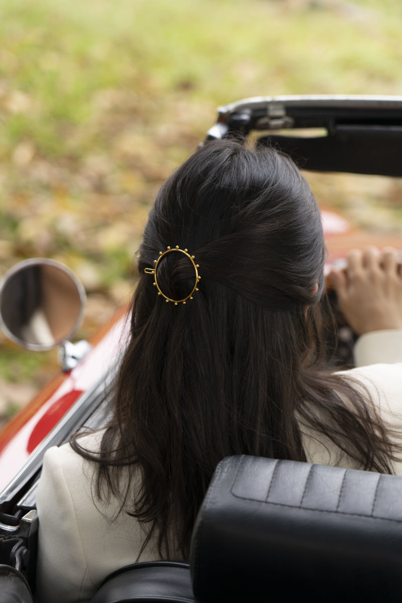 barrette fait main en or porté par une mariée dans une voiture