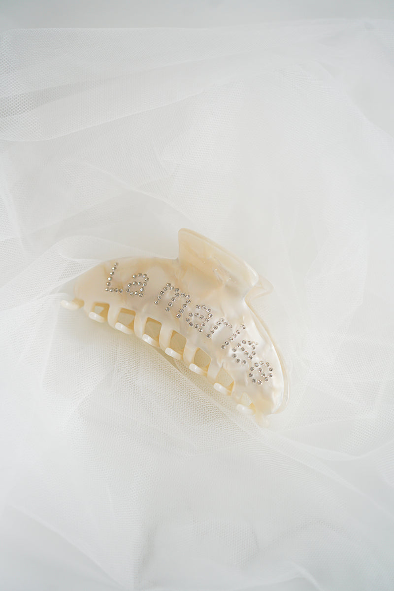 pince de cheveux pour mariage avec des strass écrit la mariée dessus posé sur un voile transparent 
