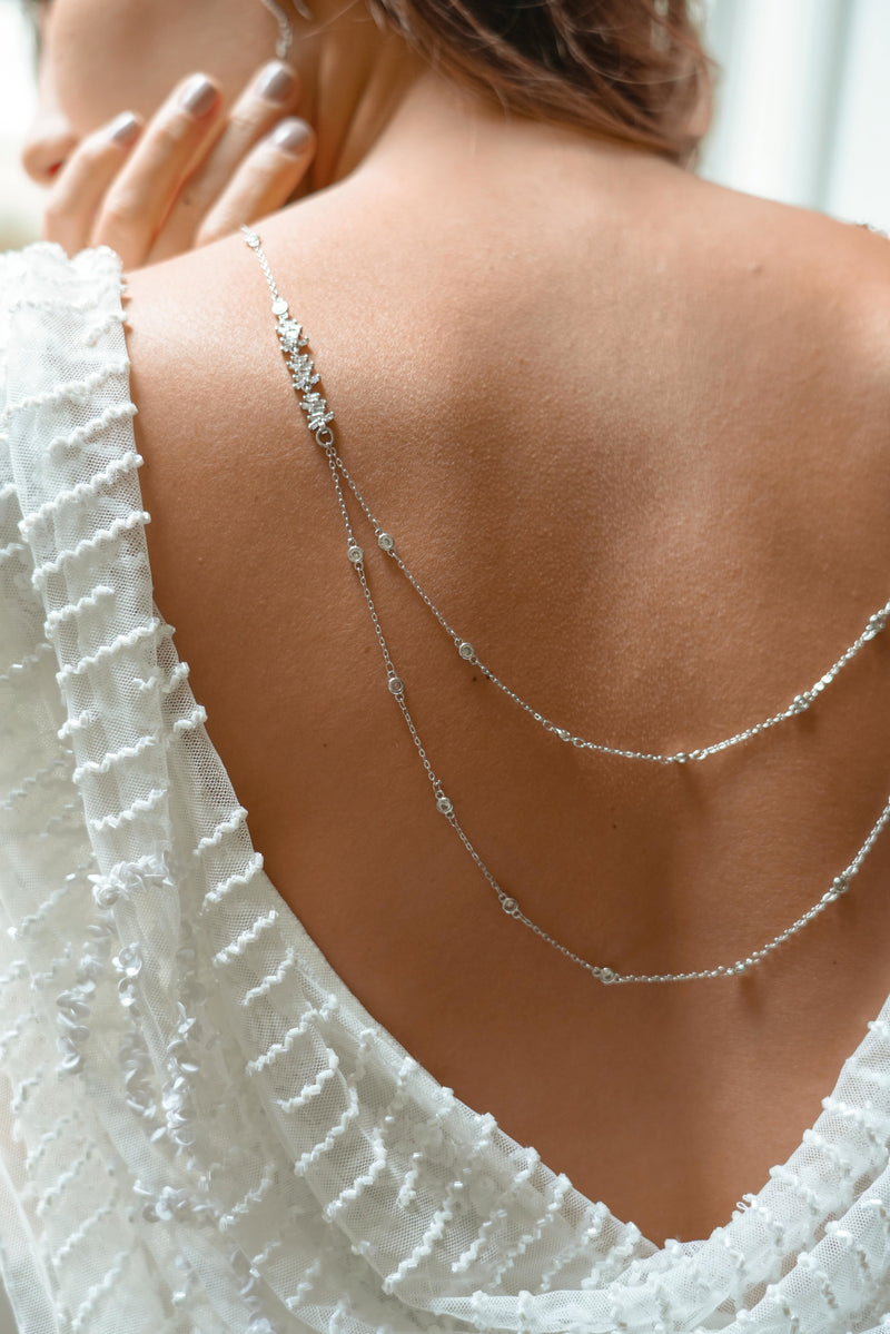 mariée portant un collier de dos en argent avec 2 étages de chaines dans le style céleste prise de près avec des zircons
