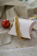 headband en or avec des cristaux et des chaines sur un emballage cadeau 