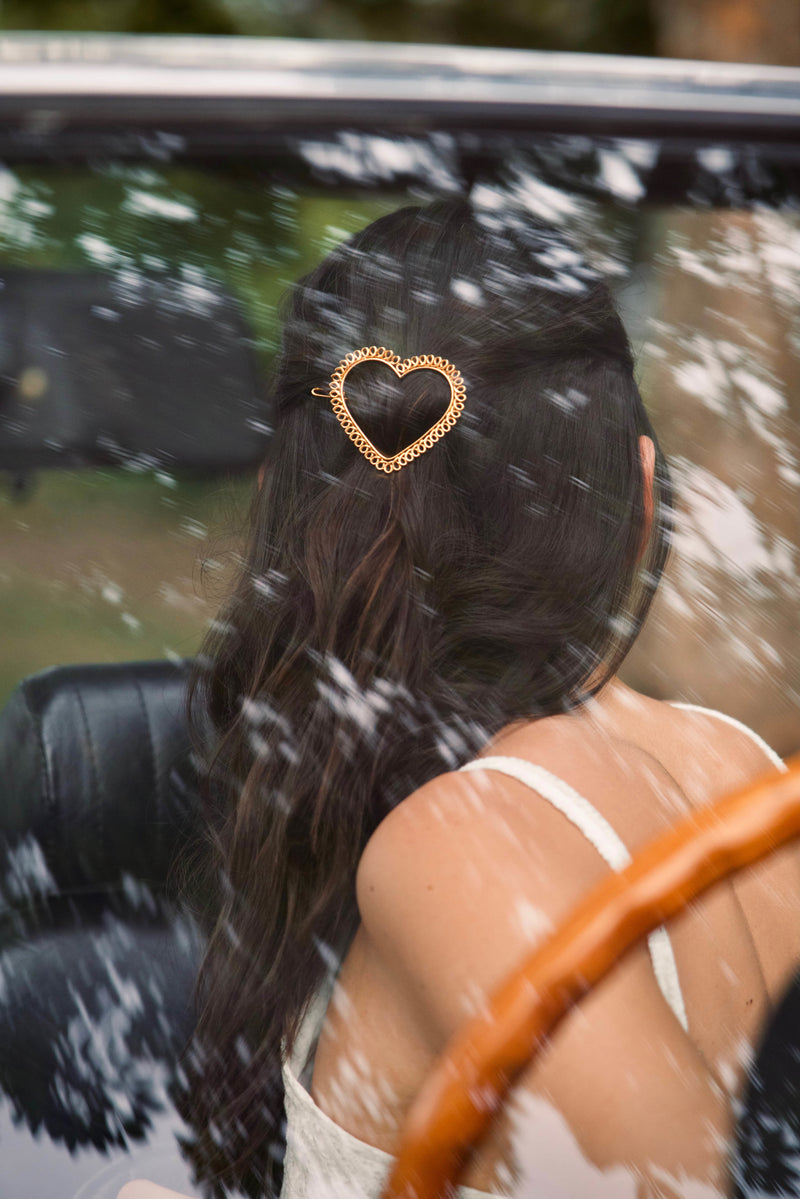 Femme avec une barrette en forme de coeur torsadé or