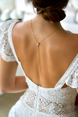 collier de dos bohème pour mariage avec un cristaux et une chaine en or pendent sur le dos de la mariée