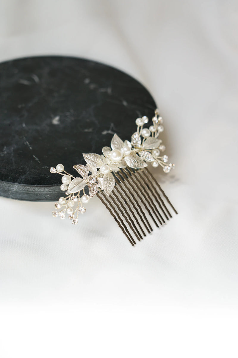 Peigne à cheveux argenté fait avec un assemblage de fleurs et de feuilles en argent, perles et cristaux